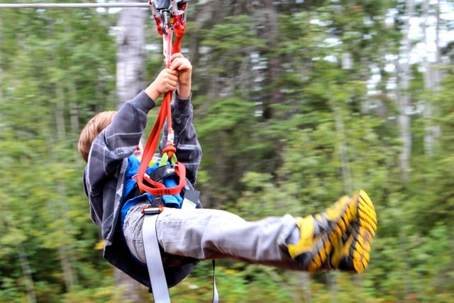 Kid in harness on zipline at Vista Ridge