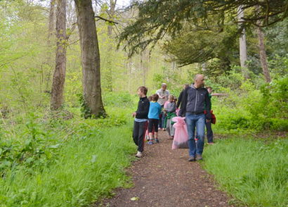 Group walking through the woods with garbage bags for litter clean up.