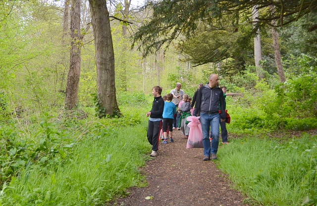 Group walking through the woods with garbage bags for litter clean up.