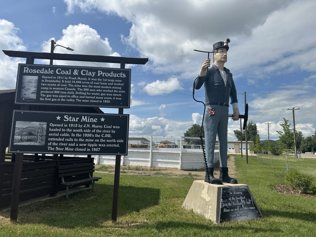 Disturbing looking giant miner statue next to the interpretive sign for "Rosedale Coal & Clay Products" and "Star Mine".