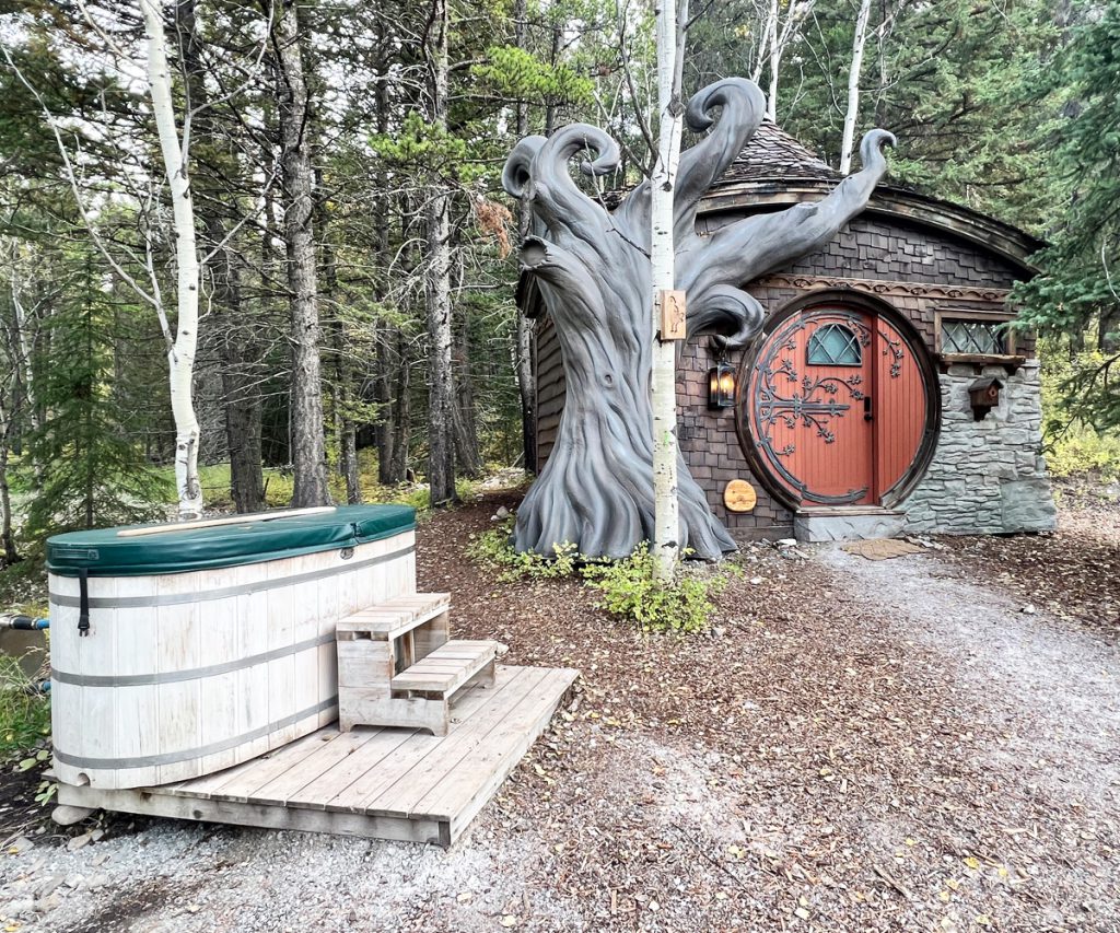 Exterior of Elvyn's Cottage and hot tub at Charmed Family Resorts in Crowsness Pass